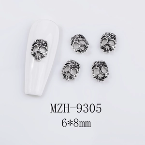 Macro shot of 6x8mm vintage silver skull nail art charm on a white mannequin nail tip