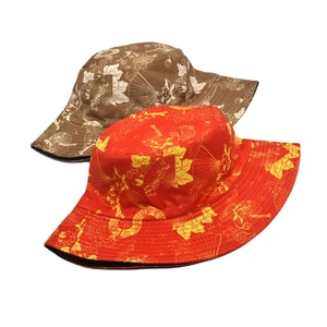 Detail of ethnic bucket hats showing traditional fan and floral patterns in red and brown