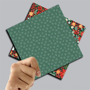 Primer plano de papel vintage para scrapbooking navideño con patrones florales rojos y verdes