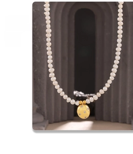 Détail d'un collier de perles d'eau douce rétro avec pendentif ovale étoilé doré
