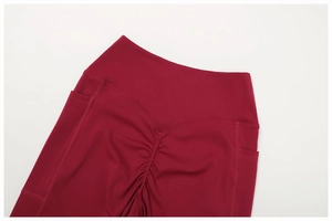 Macro detail of high-waist dark red yoga pants with scrunch butt and side pockets