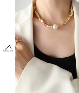 Detalle de collar de acero inoxidable con perla grande y baño de oro irregular de estilo retro
