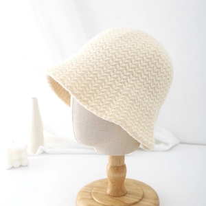 Close-up of cream knitted bucket hat showing detailed crochet texture and warm yarn