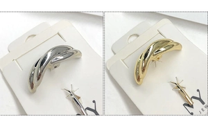 Close-up of knotted metal hair clips in gold and silver finish on display cards