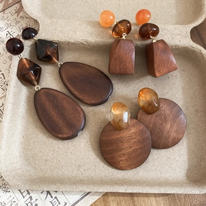Close-up of geometric wood and resin drop earrings with vintage earthy tones