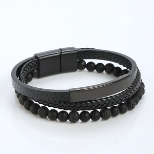 Detail of multi-layer black braided leather bracelet with magnetic clasp and metal plate