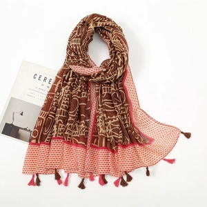 Detail of bohemian cotton linen scarf with geometric prints and fringe tassels