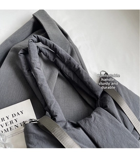 Detail of dark grey tote bag with pleated texture and reinforced top handle