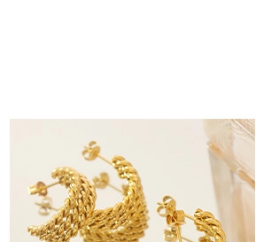 Close-up of golden twist rope hoop earrings with woven metallic texture on a reflective surface