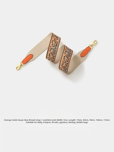 Detail of orange paisley wax thread bag strap with leather ends and gold clasps