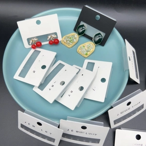 Various fashion earrings on cards inside a blue round tray for retail display