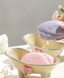 Detailed close-up of a bathtub-shaped soap dish with pink bow and silver trim details