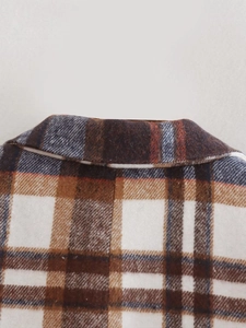 Close-up of the woven plaid wool texture and neckline on this checkered blazer