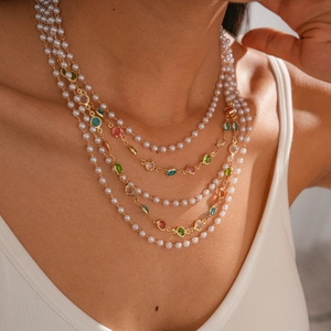 Elegant multi-layer pearl necklace with colorful gemstones and gold chain on model