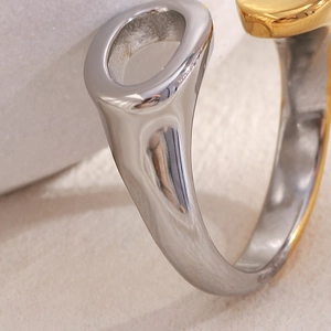 Macro shot of two-tone open ring in silver and 18K gold finish on stone background