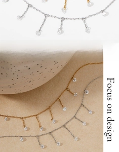 Macro detail of gold and silver necklaces featuring sparkling zircon charms in tassel style