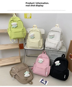 Detail view of colorful nylon backpacks in six colors with cute bear charms and side tags