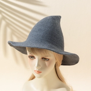 Macro shot of grey knitted witch hat texture and pointed top on mannequin head