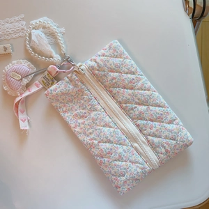 Détail de la trousse à maquillage fleurie avec poignée en perles et charm de cœur