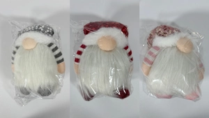 Three sequined Christmas gnomes in grey, red, and pink colors in protective packaging