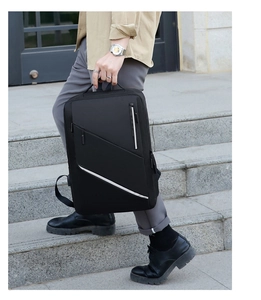 Detail showing hand-carrying black business backpack with reflective stripe and zip pocket