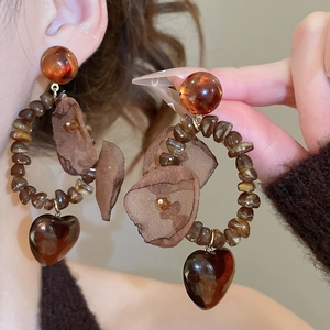 Close-up of vintage amber bead hoop earrings with dark heart charms and mesh petals