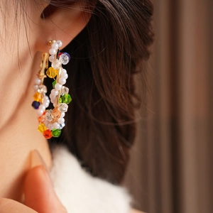 Detailed close-up of vintage hoop earrings with colorful crystals and white pearls