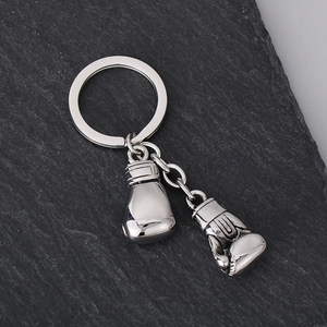 Detail of polished stainless steel boxing glove keychain on dark stone background