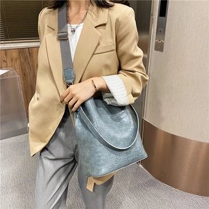 Fashionable grey blue crocodile pattern bucket bag with a wide strap for modern commuters