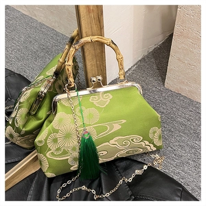 Makroansicht der Stickerei-Tasche mit Bambusgriff grüner Quaste und Metallverschluss-Detail