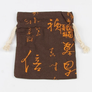 Dettaglio del sacchetto per gioielli in velluto marrone con calligrafia arancione e corda