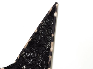 Close-up of black floral lace stitching and leopard print fabric on a summer maxi dress