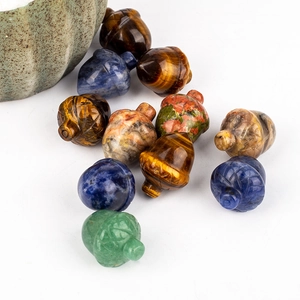 Flat lay of diverse gemstone acorn pendants including tiger eye and lapis lazuli beads
