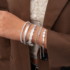 Five-piece set of silver geometric rhinestone bracelets on a model with professional styling