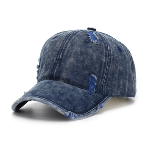Close-up of distressed denim baseball cap detailing frayed edges and torn fabric