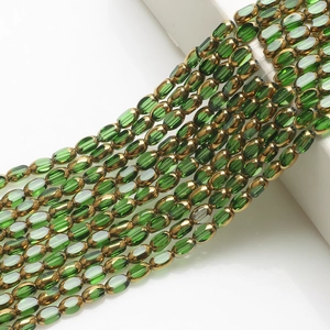 Close-up of 4x6mm green glass beads with gold trim for DIY jewelry making and craft