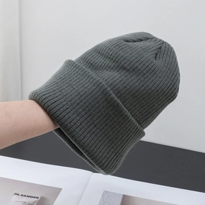 Dettaglio del berretto in maglia a coste grigio scuro con trama spessa ed elastica