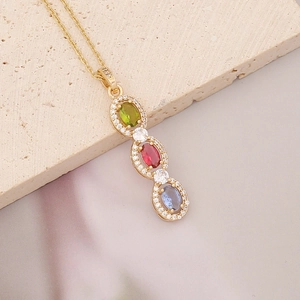 Macro view of gold pendant with green, red, blue gemstones and micro zircon stones