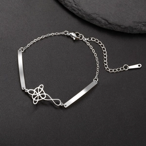 Stainless steel bracelet with polished clover charm and lobster clasp on dark stone