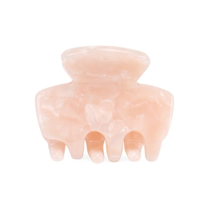 Close-up of small pink acetate hair claw clip with geometric pattern on white background