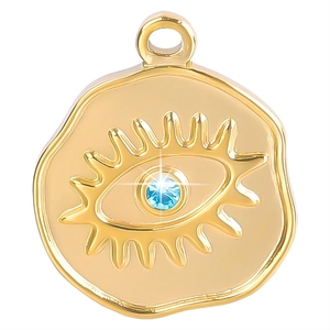 Macro shot of gold-plated Evil Eye disc pendant with a bright blue center gemstone
