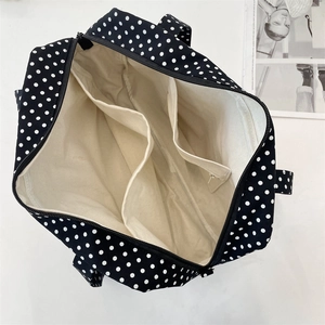 Internal view of black and white polka dot canvas tote with three organized compartments