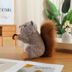 Cute plush squirrel toy holding an acorn on a wooden table with home decor background