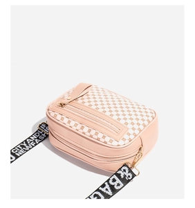 Close-up of pink PU leather camera bag with geometric embroidery and wide strap