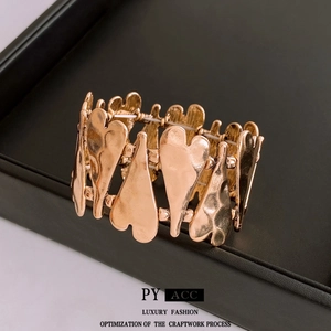 Rose gold heart-shaped elastic bracelet with hammered texture on black leather display