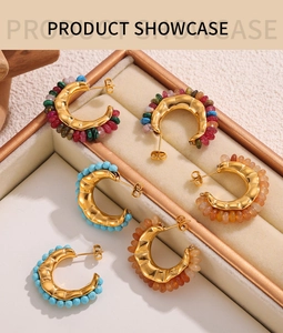 Close-up of beaded hoop earrings in gold setting displayed in a luxury jewelry showcase