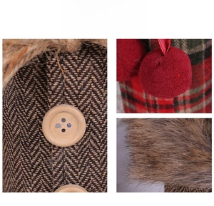 Detail of Christmas wine bottle cover featuring herringbone tweed, wood button and red pompom