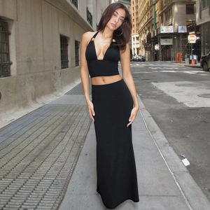 Detail of black two-piece set featuring a halter crop top and high-waisted maxi skirt