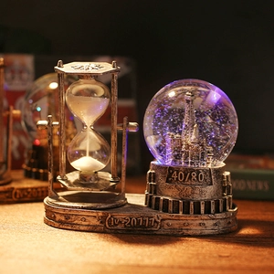 Macro detail of vintage hourglass and Eiffel Tower crystal ball with antique silver texture