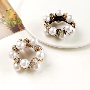 Detail of white pearls and gold crystal charms on elastic hair ties for ponytails